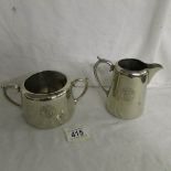 A silver plated P & O milk jug and sugar bowl with rising sun motif.