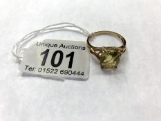 A gold ring set with a citrine stone with fancy cross over shoulders in 9ct, Size V.