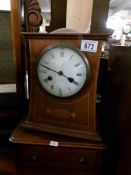 An Edwardian mahogany inlaid mantel clock, in working order and with key.