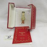 A boxed 18ct gold Cartier wrist watch set with diamonds.