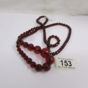 A long bakelite cherry coloured necklace.