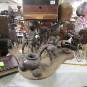 An unusual coffee table with tribal village group base and glass top.