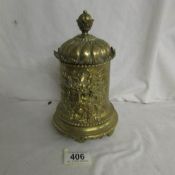 A heavy brass tobacco jar with embossed 'Green Man' depiction complete with liner.