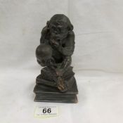 A 1920s spelter table lighter depicting Charles Darwin's 'The Thinker' (a monkey holding a skull).