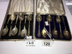 2 cased sets of golf related silver teaspoons.