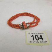 A 1950s natural coral bracelet with gold clasp.