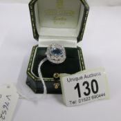 A platinum ring set with central aquamarine surrounded by diamonds, size M.