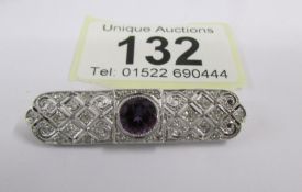 An Art Deco diamond set brooch with central amethyst set in platinum.