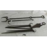 A collection of 18th century hearth accoutrements featuring spit hanger, roasting fork,