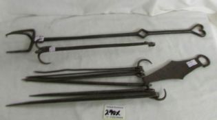 A collection of 18th century hearth accoutrements featuring spit hanger, roasting fork,