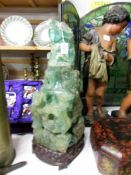 A tall heavy piece of carved jade on original stand, a/f.