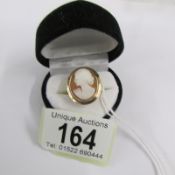 A vintage cameo in an oval mount, profile of a young woman, in 9ct gold.