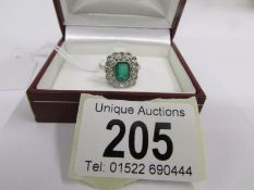 A white gold ring set central emerald and diamonds, size Q.