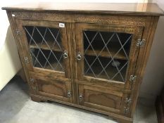 An oak cabinet with lead glazed doors.