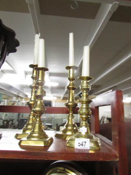 A pair of brass candlesticks and one other.