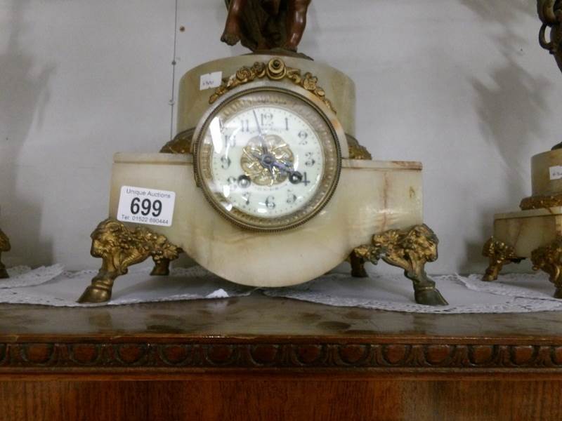 A 3 piece clock garniture comprising clock surmounted mother with child and pair of candelabra. - Image 2 of 4