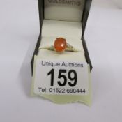 A fire opal ring with diamond shoulders in gold, size P half.