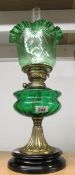 An oil lamp on pot base with green glass font and later green glass shade.