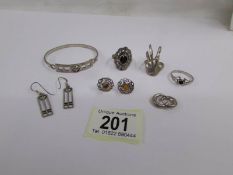 3 silver rings, 3 pairs of silver earrings and a silver bangle.