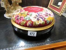 A Victorian ebonised and tapestry footstool.