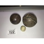 An antique leather ball, a wooden ball (possibly cricket) and a miniature ball.