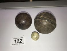 An antique leather ball, a wooden ball (possibly cricket) and a miniature ball.