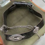 A Royal Ulster Rifles leather belt featuring silver badges, chain and whistle.