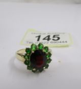 A garnet and tourmaline cluster ring in gold, size T half.