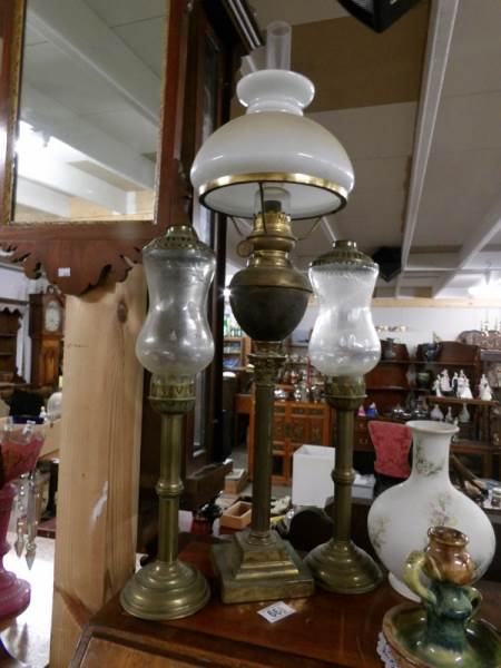 A brass oil lamp and 2 brass candle lamps.