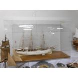 A model of the sailing ship 'The Danmark' in a plastic case.