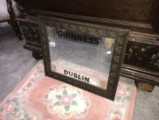 A Guinness Dublin mirror in carved wooden frame