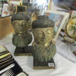 A pair of contemporary carved soft wood heads of Buddha.