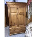 A pine double wardrobe on drawer base