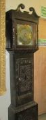 A carved oak Grandfather clock with brass dial.