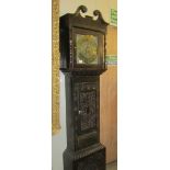 A carved oak Grandfather clock with brass dial.