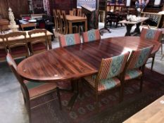 A large oval extending dining table with 2 leaves and 6 upholstered chairs