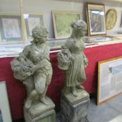 A pair of garden statues of a boy and girl on plinths ****Condition report**** Girl