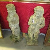 A pair of 'Boy in coat' garden statues, 77 cm tall.