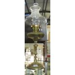 A brass oil lamp with cranberry font and complete with shade.