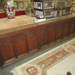 An oak Victorian Gothic pew front with shelf featuring a memorial carving to one side