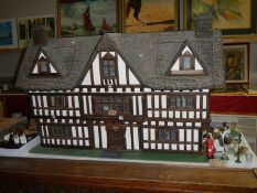 A large Elizabethan style dolls house complete with furniture.
