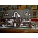 A large Elizabethan style dolls house complete with furniture.