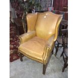 A tan leather wing armchair