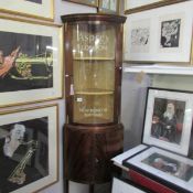 A mahogany corner display cabinet with Asprey London painted sign writing.