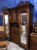 An Edwardian mirrored wardrobe with centre drawers and cabinet
