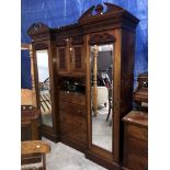 An Edwardian mirrored wardrobe with centre drawers and cabinet