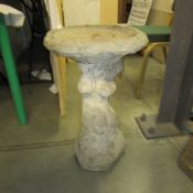 A concrete garden bird bath.