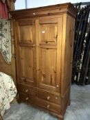 A pine double wardrobe with bottom drawers