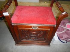 An Edwardian piano stool with drop down front.