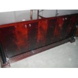 A large dark wood stained 4 door sideboard
